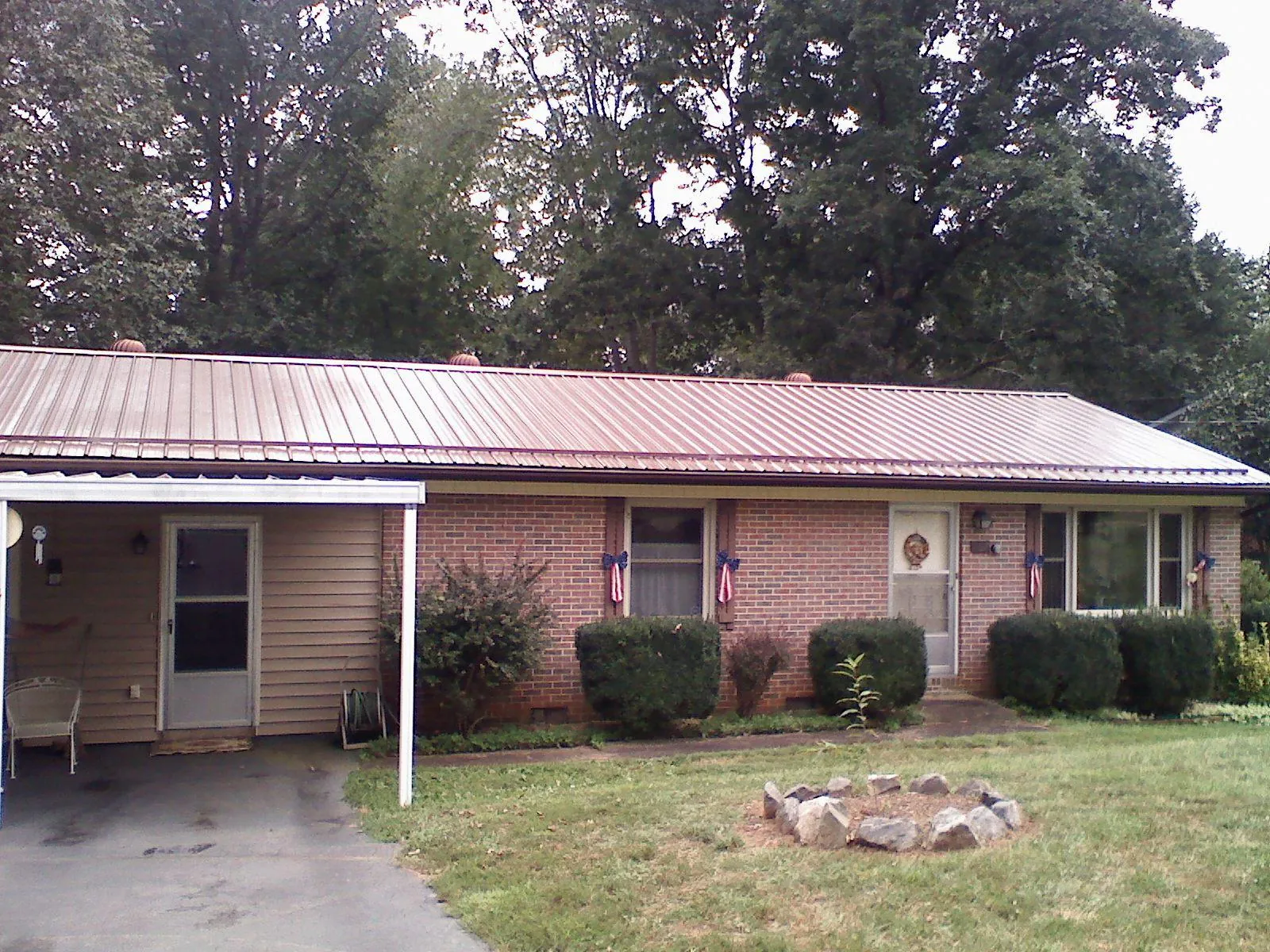 Bronze metal roof and carport on a brick ranch home — Roof Repair work by our crew in Grand Ridge